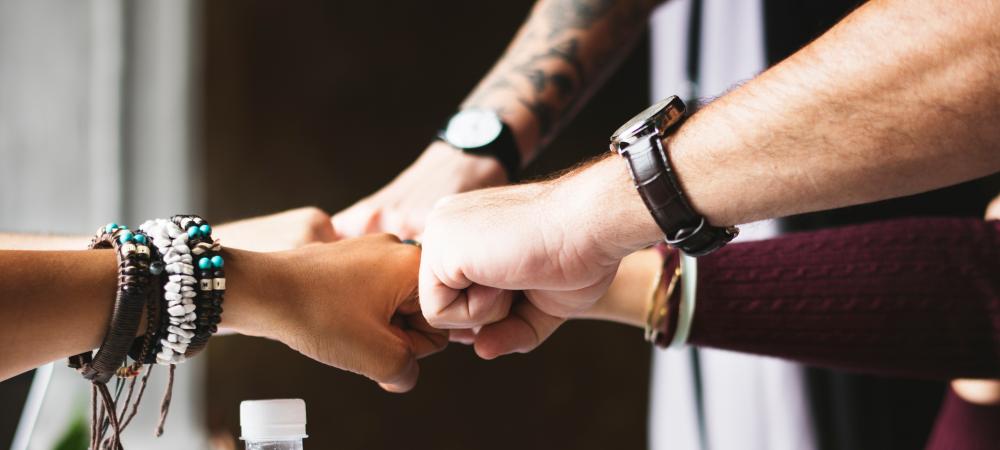 Group of people fist bumping